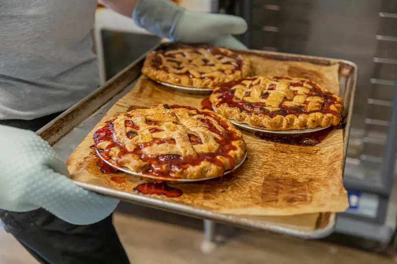 Lattice-top pies coming out of the oven on a baking sheet