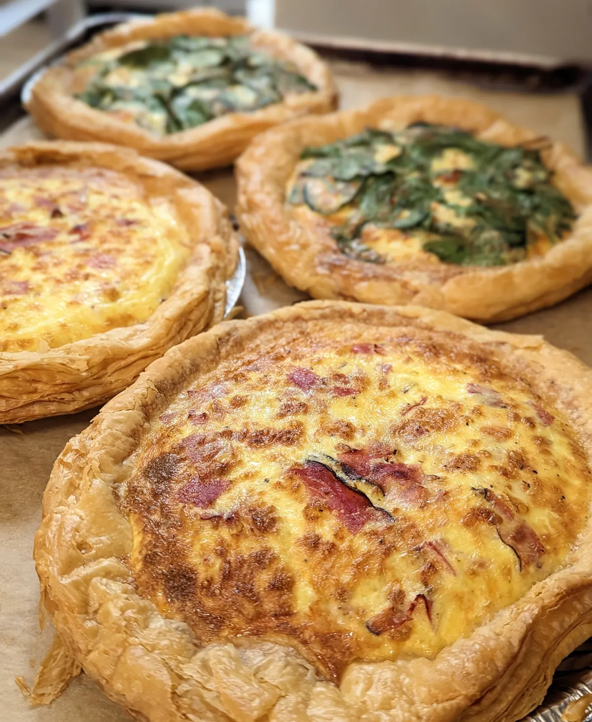 Freshly baked quiches, including spinach and a golden cheese quiche