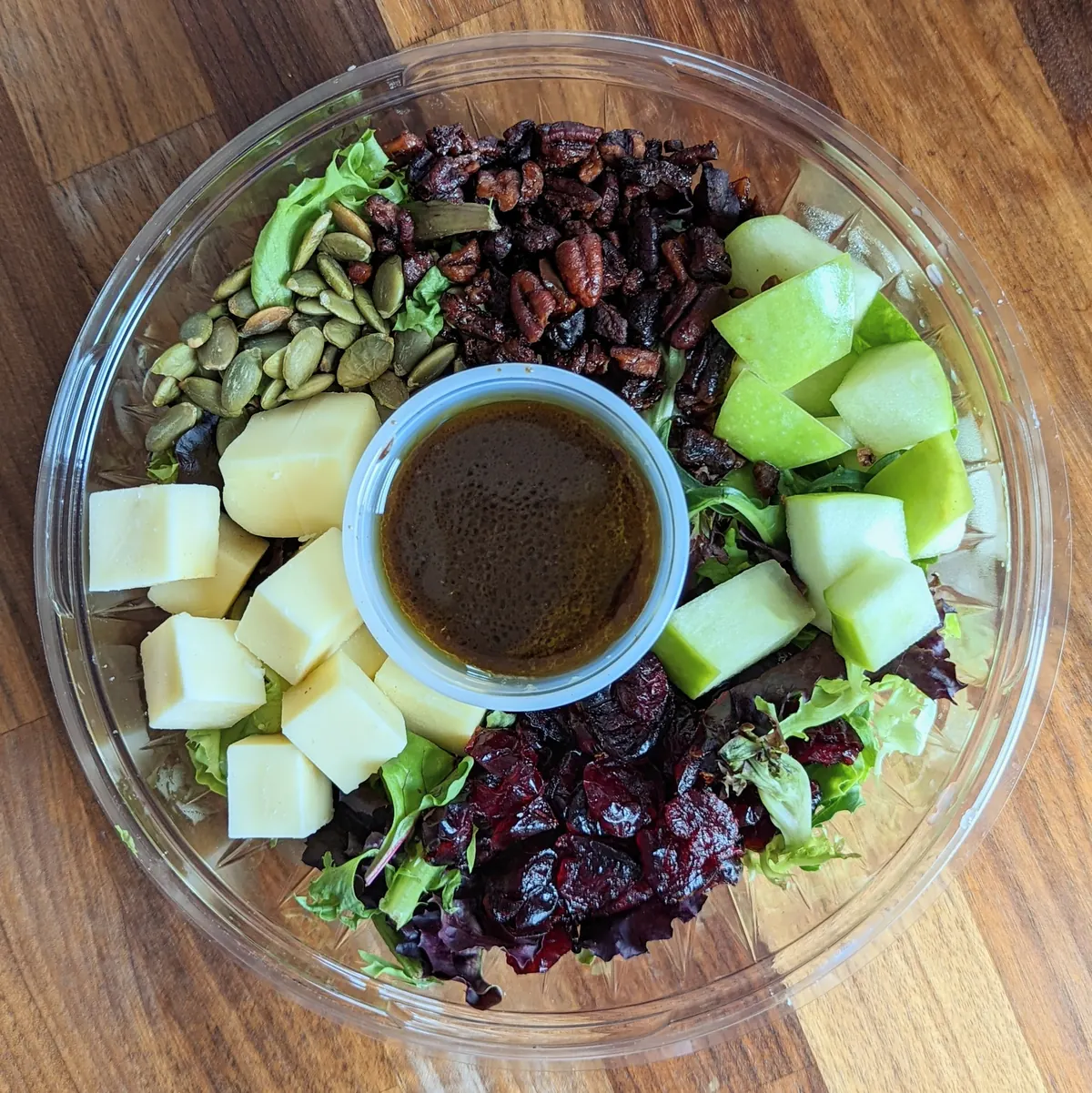 Salad bowl with apples, cheese, cranberries, pecans and pumpkin seeds